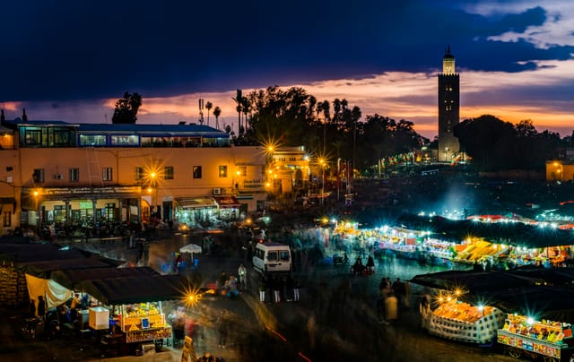 Jemaa el-Fnaa square in Marrakech at night with the Koutoubia minaret and lit market stalls
