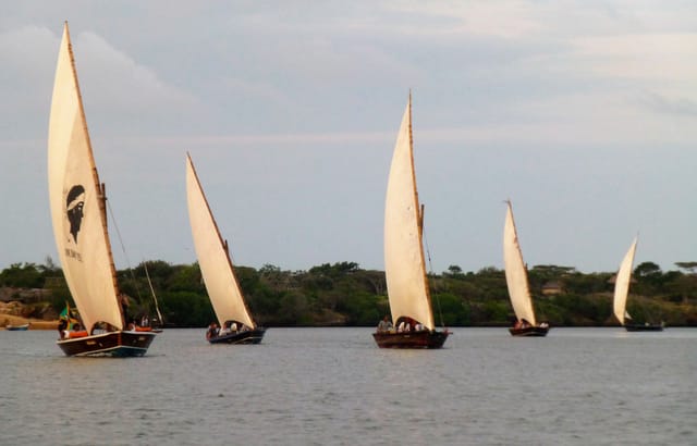 Traditional dhows under sail off Lamu on Kenya's Swahili coast, the same sewn-boat tradition that carried East Africa's ancient trade.